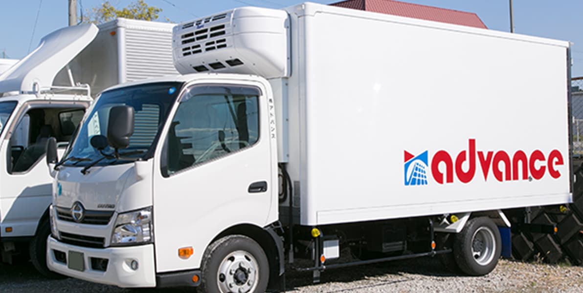 株式会社アドバンスのロゴがペイントされた輸送用トラック